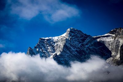 Low angle view of snowcapped mountains against sky