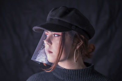 Close-up of young woman wearing cap and plastic at home
