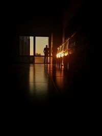 Rear view of silhouette man in illuminated room