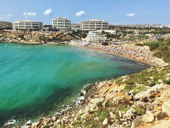 Scenic view of sea by buildings against sky