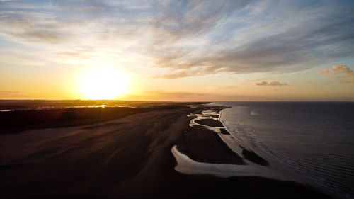 Scenic view of beach against sky during sunset