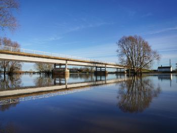 Empty bridge reflected in wide river