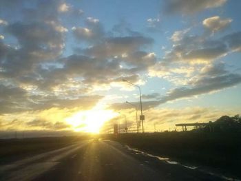 Road against cloudy sky at sunset