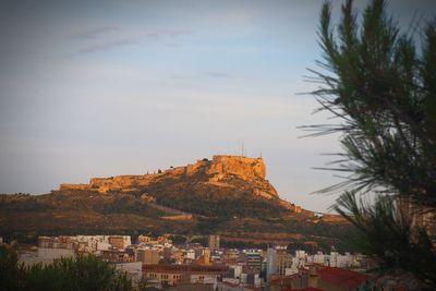 View of town by mountain against sky