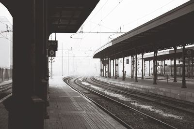 Railway tracks at railroad station against sky