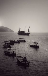 Boats sailing in sea against clear sky