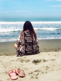 Woman on beach by sea against sky