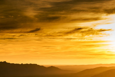 Scenic view of silhouette mountains against sky during sunset