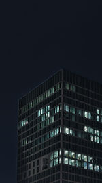 Low angle view of illuminated buildings against sky at night