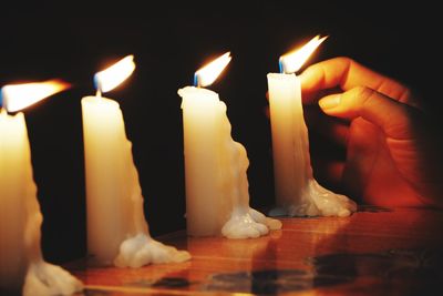 Close-up of candles burning in darkroom