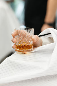 Midsection of woman holding drink on table