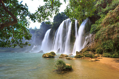 Scenic view of waterfall against sky