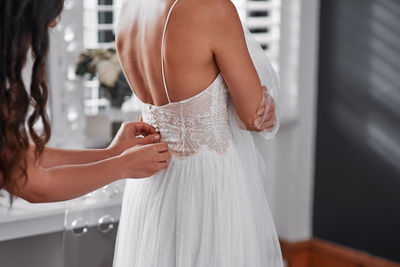 Midsection of bride holding bouquet