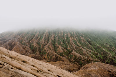 Scenic view of landscape against sky during foggy weather