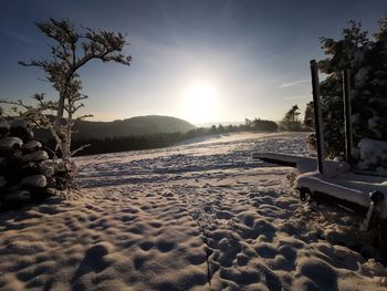 Scenic view of snow covered land against sky during sunset