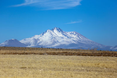 Scenic view of snowcapped mountains against clear blue sky