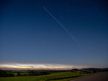 Scenic view of field against clear sky at night