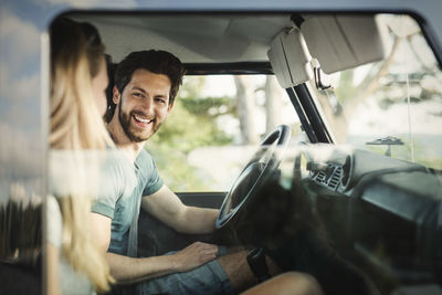 Happy man enjoying road trip with woman