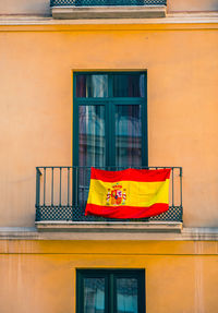 Close view of facade with windows and spanish flags.