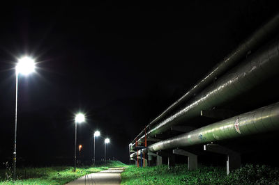 Low angle view of illuminated lights against sky at night