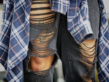 Cropped image of woman wearing ripped jeans