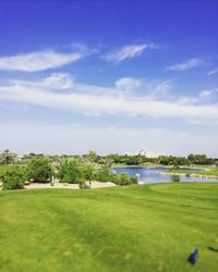 Scenic view of golf course against sky