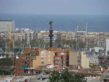 High angle view of buildings by sea against clear sky