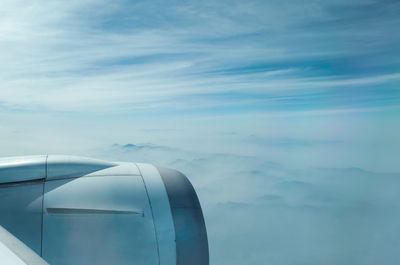 Airplane flying over cloudscape against blue sky