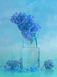 Close-up of flower vase against blue background