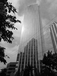 Low angle view of modern building against cloudy sky