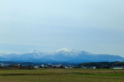 Scenic view of field and mountains against sky