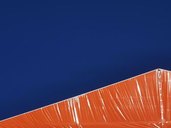 Low angle view of umbrella against clear blue sky