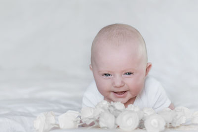 Portrait of cute baby girl lying on bed