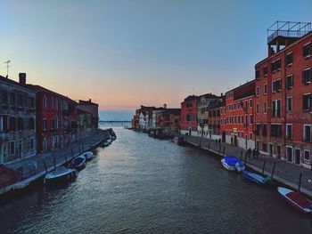 Canal amidst residential buildings against clear sky