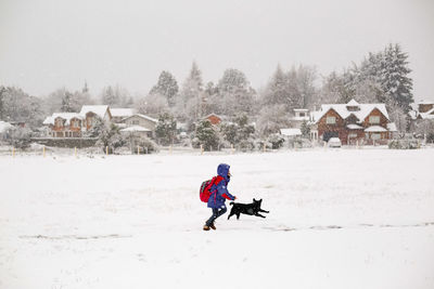 Full length of boy skiing on snow covered field