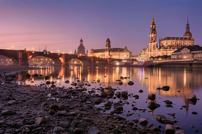 Elbe river against illuminated buildings in city