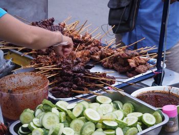 Midsection of man buying food at market stall