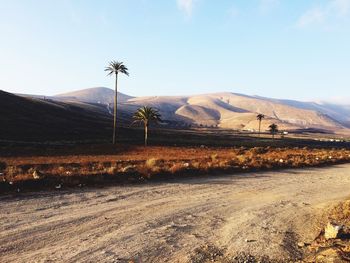 Scenic view of road by mountains against sky