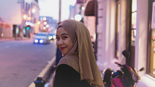 Smiling woman wearing hijab during sunset