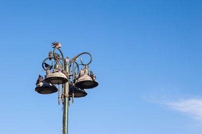 Low angle view of street light against blue sky