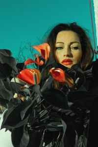 Portrait of young woman with red flower