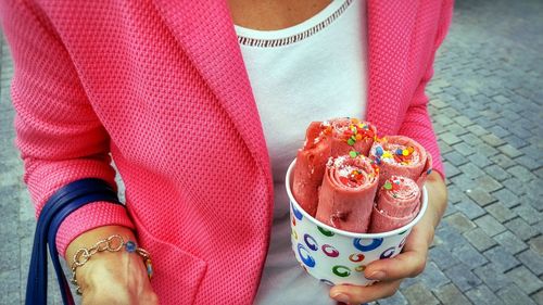 Midsection of woman holding ice cream roll