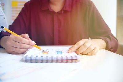 Midsection of woman working at table