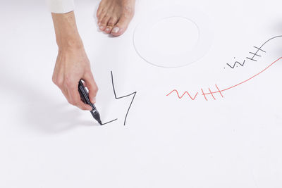 High angle view of hand on paper over white background