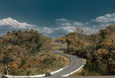 High angle view of road amidst trees against sky