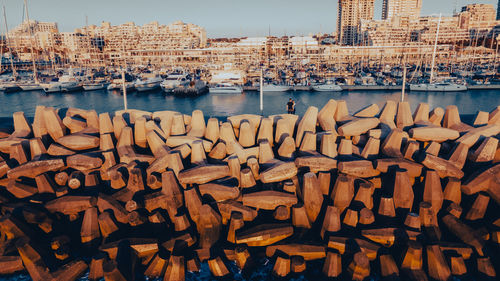 Sailboats in sea against buildings in city