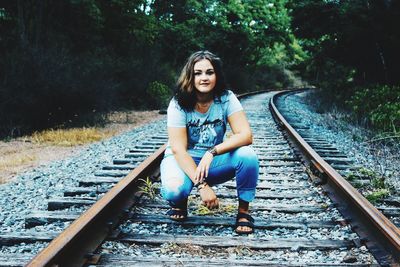 Young woman standing on railroad track