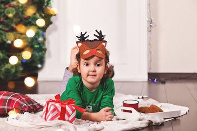 High angle view of cute girl playing with christmas tree at home