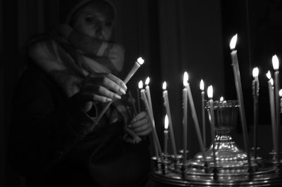 Midsection of woman holding illuminated candles