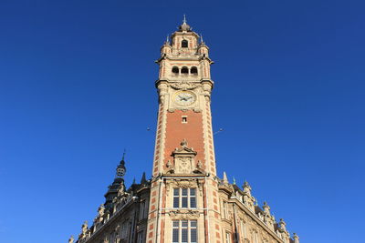 Low angle view of clock tower against blue sky